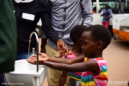 Twin sisters, Emeline and Eveline, wash their hands at a public hand washing station as a cautionary measure against the coronavirus.