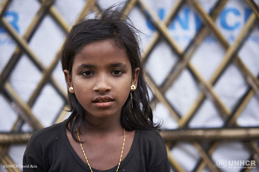 Rohingya refugee Nur Kalima, 10, poses for a photograph outside her family's shelter in an area that has been levelled and made safer in Kutupalong Expansion Site for Rohingya refugees.