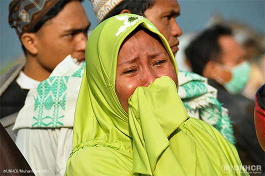 A woman cries as people look at the damage after an earthquake and tsunami in Palu, on the island of Sulawesi.