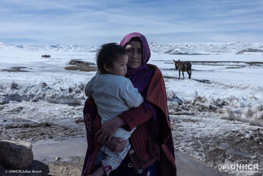 Zahra, 34, with her young daughter in front of her house in Sabzi, Bamyan province.