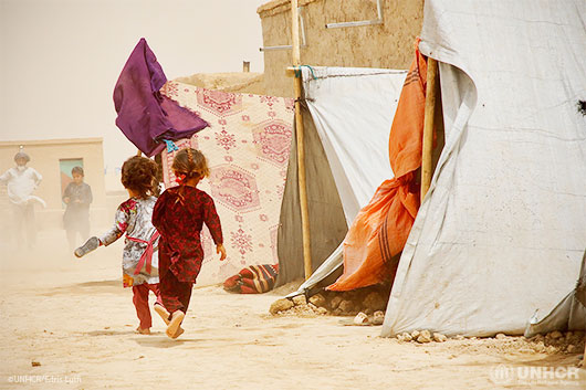 Children run for shelter from high winds and dust in Nawabad Farabi-ha camp for internally displaced people in Mazar-e Sharif, northern Afghanistan.