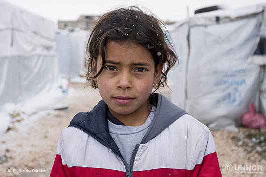 Syrian refugee Taghrid, 13, standing on the middle of the refugee camp searching for a space to breath. The tent she lives in is crowded with MANY people.