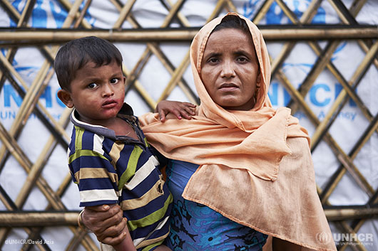 Rohingya refugee Khadija, 40, holding her son Saiful Hoque, 4, poses for a photograph outside the family's shelter.