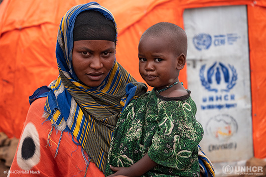 A refugee woman holding her child at the Juba camp in Somalia